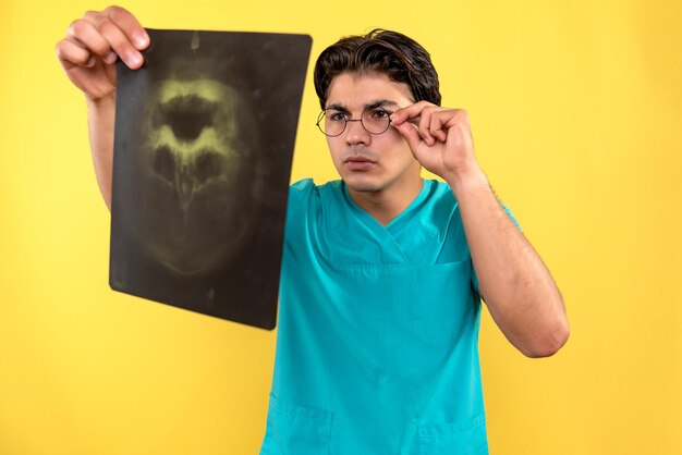 Vue de face du médecin de sexe masculin tenant une radiographie