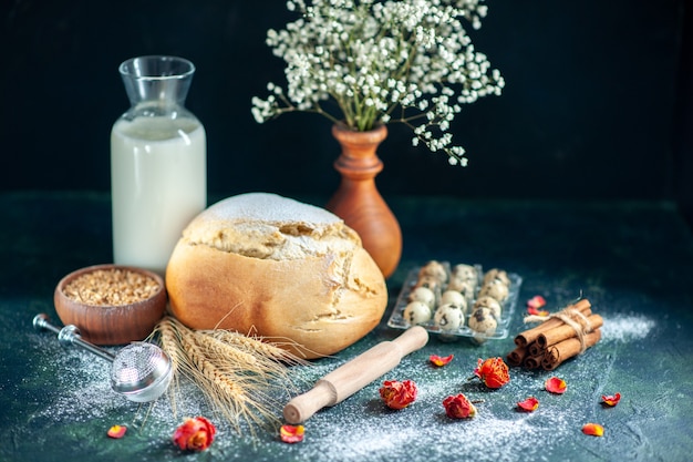 Vue de face du pain frais avec du lait et des œufs sur un gâteau bleu foncé, une tarte aux biscuits, une tarte au thé, une pâte à petit-déjeuner, un pain à pâtisserie, du sucre