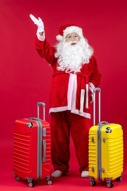 Vue De Face Du Père Noël Avec Deux Sacs Se Préparant Pour Le Voyage Sur Le Mur Rouge