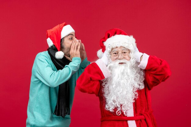 Vue de face du père noël avec un homme interagissant sur le rouge présent noël émotion vacances nouvel an