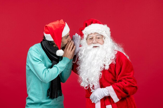 Vue de face du père noël avec un homme juste debout sur des vacances d'émotions de noël rouges présentes