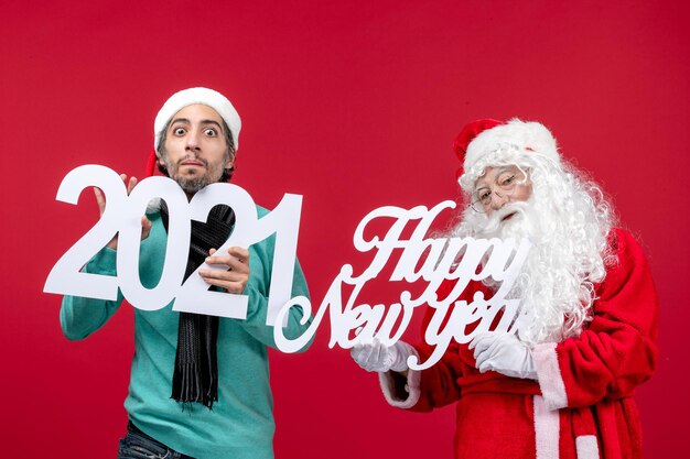 Vue de face du père noël avec un homme tenant et bonne année écrivant le nouvel an rouge noël