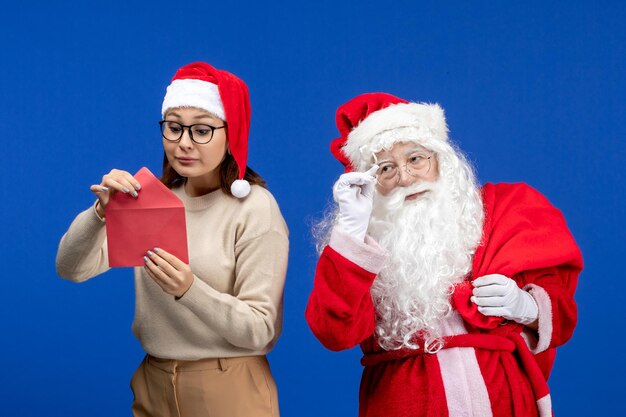 Vue de face du père noël et de la jeune femme lettre d'ouverture sur l'émotion de vacances bleu noël nouvel an