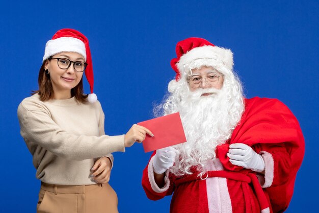 Vue de face du père noël et de la jeune femme tenant une lettre sur l'émotion de couleur bleu vacances noël nouvel an