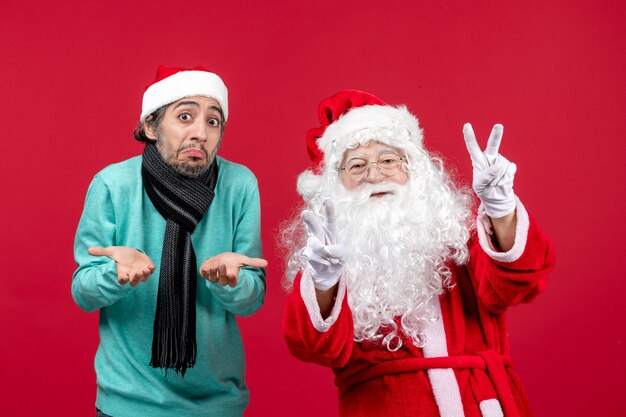 Vue de face du père Noël avec jeune homme debout juste