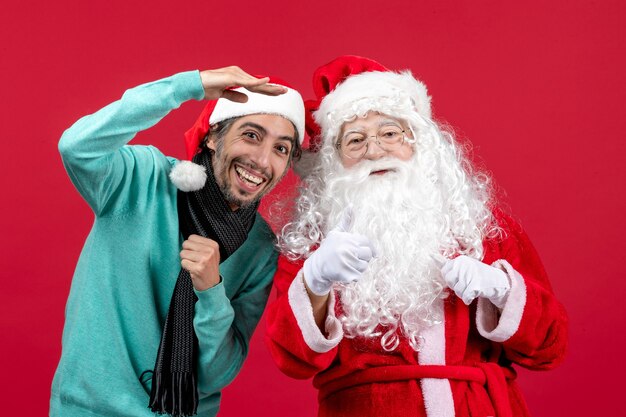 Vue de face du père Noël avec jeune homme debout juste