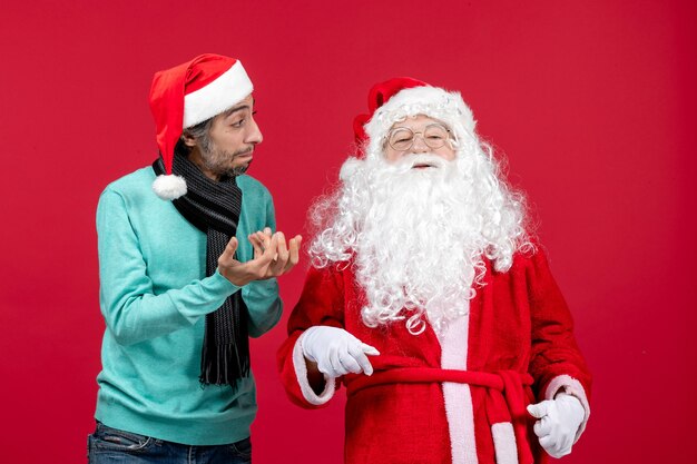 Vue de face du père Noël avec jeune homme debout juste