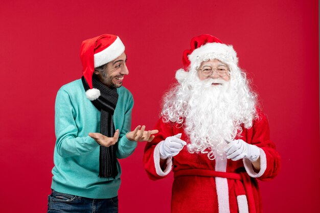 Vue de face du père Noël avec jeune homme debout juste