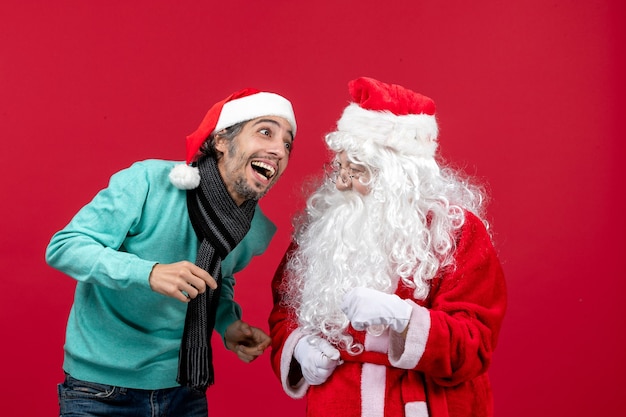 Vue de face du père Noël avec jeune homme debout juste