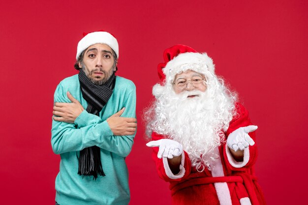 Vue de face du père Noël avec jeune homme debout juste