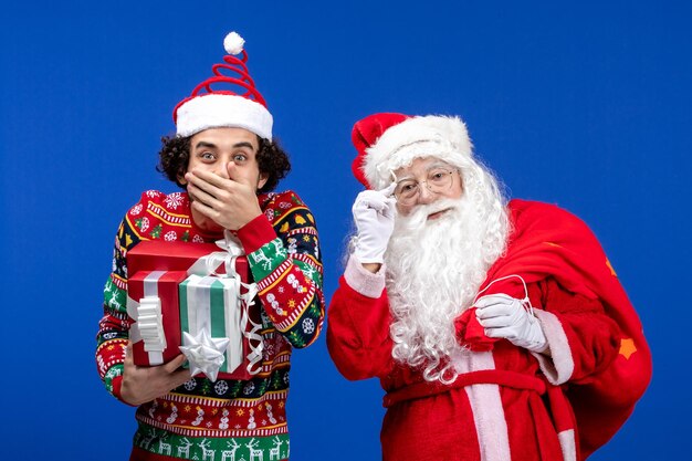 Vue de face du père noël avec un jeune homme et présente des émotions de vacances de noël de couleur bleue