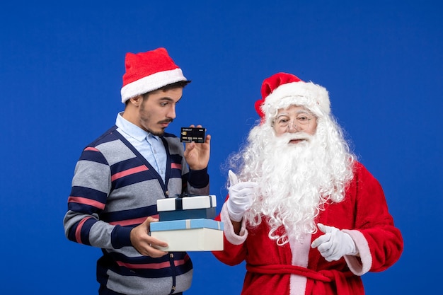 Vue de face du père Noël avec jeune homme tenant des cadeaux