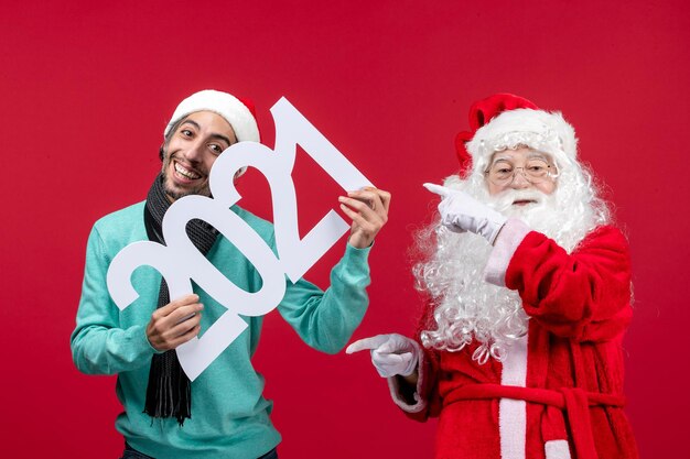 Vue de face du père noël avec un jeune homme tenant l'écriture sur l'émotion rouge nouvel an vacances de noël présent