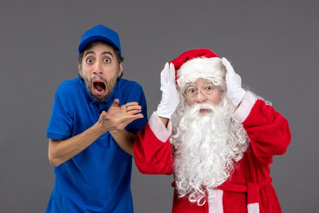 Vue de face du père Noël avec messager masculin sur le mur gris