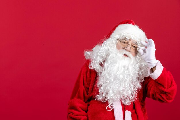 Vue de face du père noël avec un ours blanc classique et des vêtements rouges debout sur les vacances du nouvel an de noël rouge