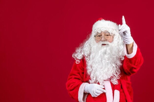 Vue de face du père noël avec un ours blanc classique et des vêtements rouges debout sur les vacances du nouvel an de noël rouge