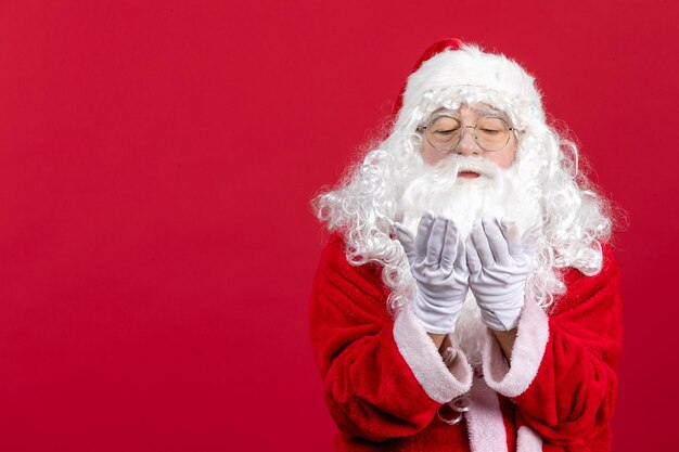 Vue de face du père noël avec un ours blanc classique et des vêtements rouges envoyant des baisers aériens le nouvel an de noël rouge