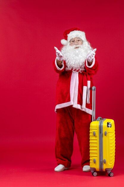 Vue de face du père noël portant un sac jaune se préparant au voyage