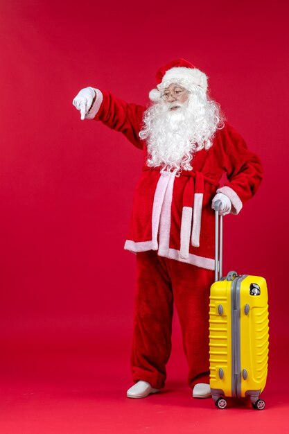 Vue de face du père noël portant un sac jaune se préparant au voyage