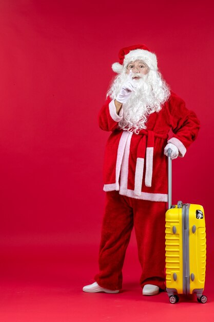 Vue de face du père noël portant un sac jaune se préparant au voyage