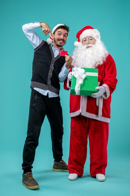 Vue de face du père noël tenant un cadeau avec un jeune homme