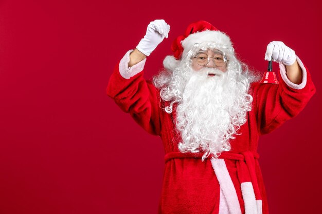 Vue de face du père noël tenant une petite cloche sur les vacances d'émotion du cadeau du nouvel an de noël rouge