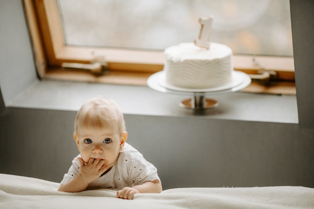 Vue de face du petit enfant de sexe féminin debout près d'une fenêtre