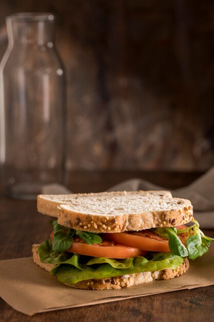 Vue de face du sandwich avec des légumes verts et des tomates