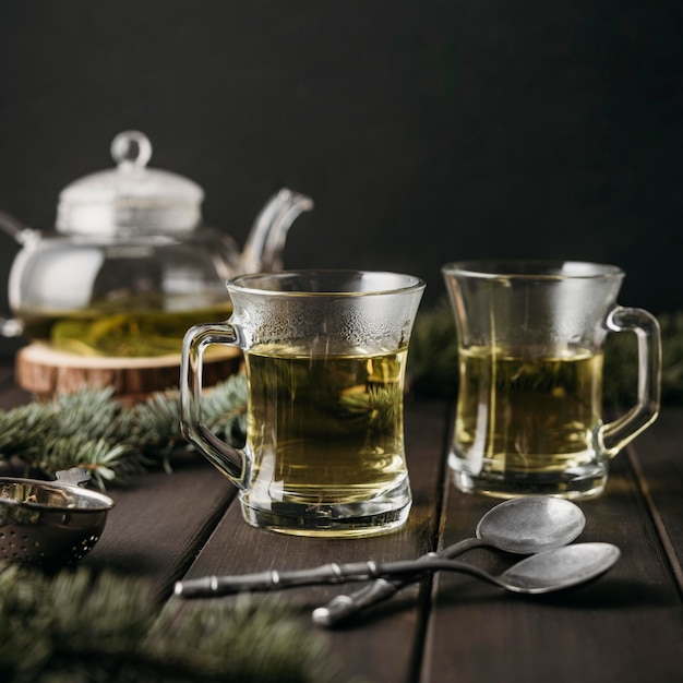 Vue de face du thé dans des verres avec des cuillères à café