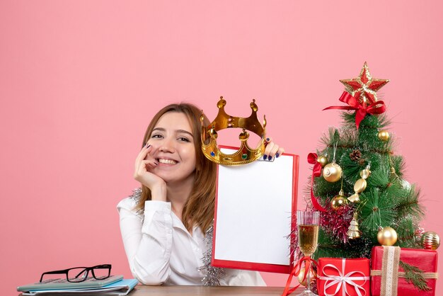 Vue de face du travailleur féminin avec couronne et note de dossier sur rose.