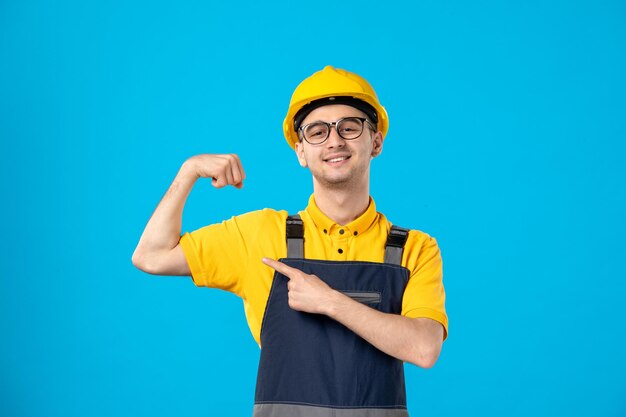 Vue de face du travailleur masculin en uniforme jaune sur fond bleu