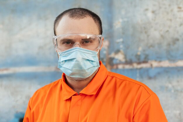 Vue de face du travailleur en uniforme avec masque médical