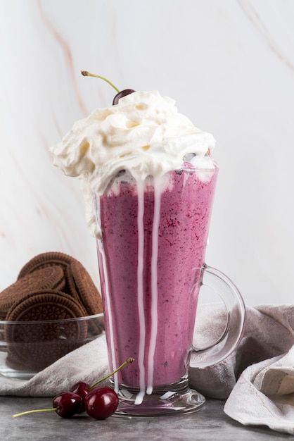 Vue de face du verre avec dessert et crème fouettée