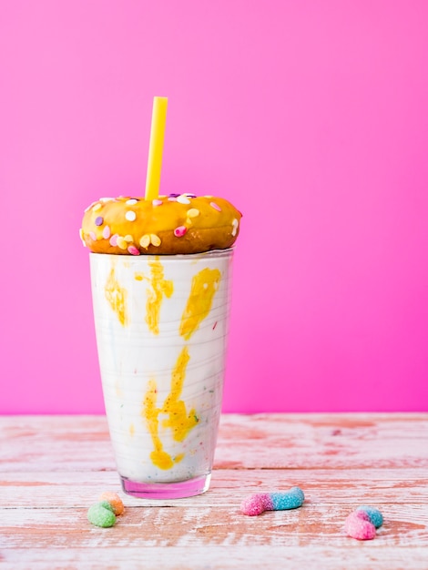 Vue de face du verre de milkshake avec fond rose