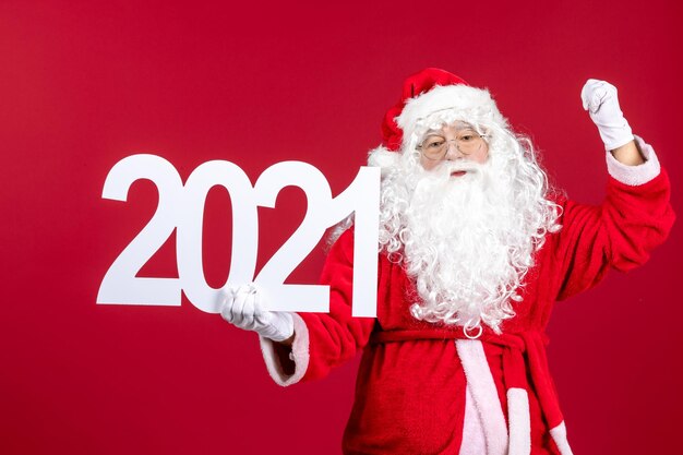 Vue de face du vieux père noël tenant l'écriture sur le mur rouge