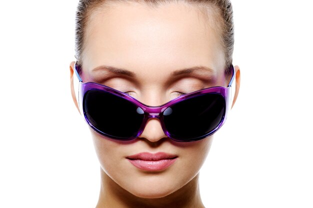 Vue de face du visage féminin dans des lunettes de soleil violet foncé