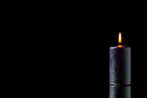 Vue de face de l'éclairage de bougie sombre sur une surface sombre