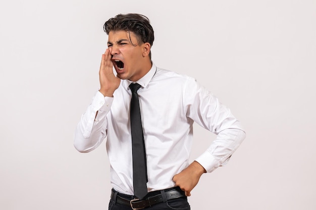 Vue de face employé de bureau masculin appelant au mur blanc travail entreprise d'emploi masculin