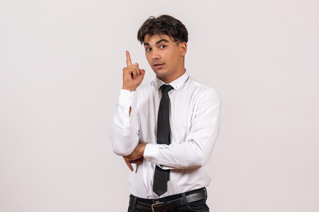 Vue de face employé de bureau masculin debout sur un mur blanc travail de bureau homme humain