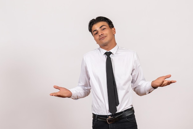 Vue de face employé de bureau masculin posant sur un mur blanc travail entreprise d'emploi masculin