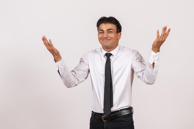 Vue de face employé de bureau masculin posant sur un mur blanc travail entreprise d'emploi masculin