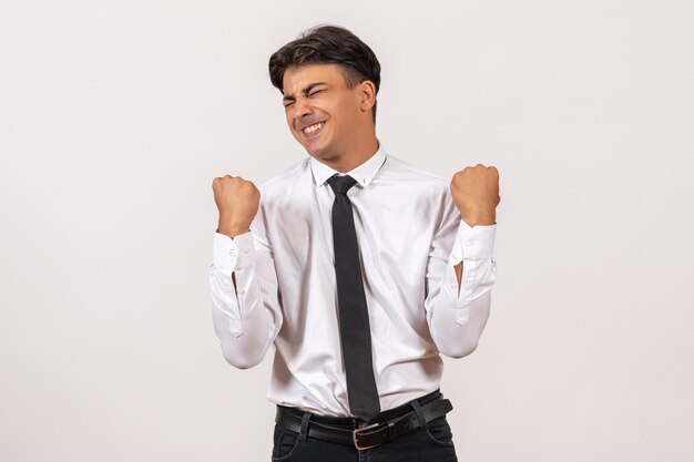 Vue de face employé de bureau masculin se réjouissant d'un travail de bureau de mur blanc humain