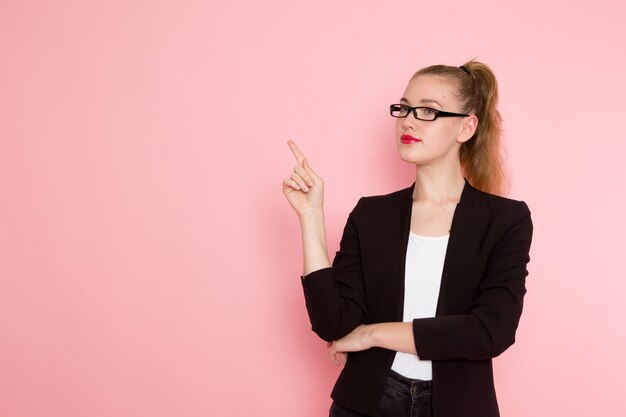 Photo gratuite vue de face de l'employée de bureau en veste noire stricte posant sur le mur rose