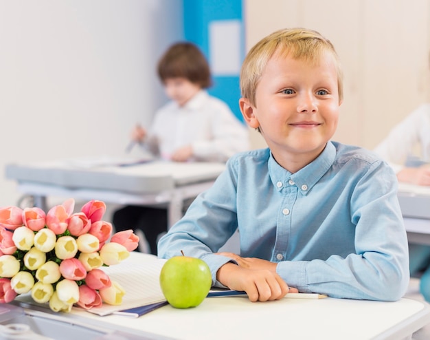 Vue de face enfant assis à côté de cadeaux pour son professeur