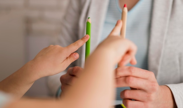 Vue de face d'un enfant comptant à la maison à l'aide de crayons