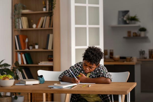 Photo gratuite vue de face enfant faisant ses devoirs à la maison