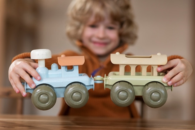 Photo gratuite vue de face enfant flou jouant avec un train écologique