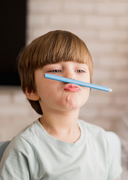 Vue de face de l'enfant posant idiot pendant la session de tutorat