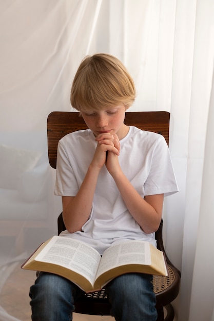 Photo gratuite vue de face enfant priant à l'école du dimanche