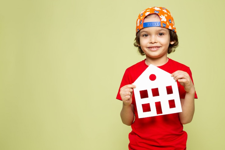 Photo gratuit une vue de face enfant souriant en t-shirt rouge et casquette de baseball sur l'espace de couleur pierre
